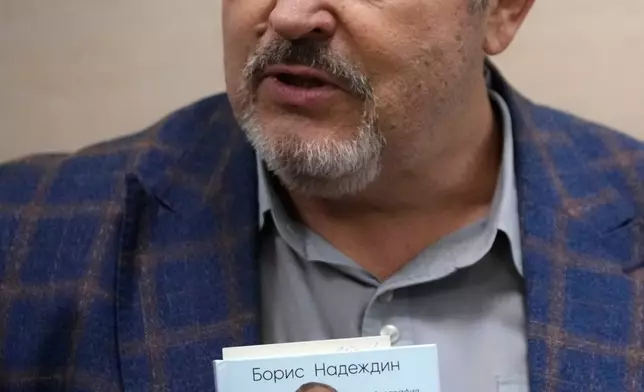 Russian politician Boris Nadezhdin, accused of displaying "extremist symbols," holds an autobiography while attending a court session in the town of Dolgoprudny outside Moscow, Russia, Friday, July 17, 2026. (AP Photo/Pavel Bednyakov)