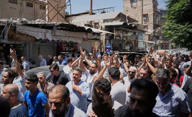 Mourners carry the coffin of Fathi Muhammad Saeed Qabbani, who was killed Tuesday when an explosive device detonated in a cafe near Damascus' main courthouse complex, during his funeral in the Al-Midan neighborhood of Damascus, Syria, Friday, July 3, 2026. (AP Photo/Omar Albam)