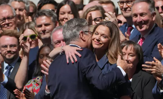 Britain's outgoing Prime Minister Keir Starmer and wife Victoria hug as they leave 10 Downing Street in London, Monday, July 20, 2026.(AP Photo/Kin Cheung)
