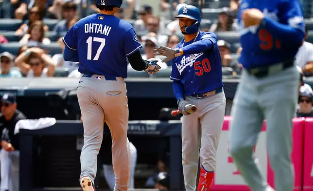 Los Angeles Dodgers' Mookie Betts (50) greets Shohei Ohtani (17) after Ohtani scored against the New York Yankees during the third inning of the first game of a baseball doubleheader, Sunday, July 19, 2026, in New York. (AP Photo/Noah K. Murray)