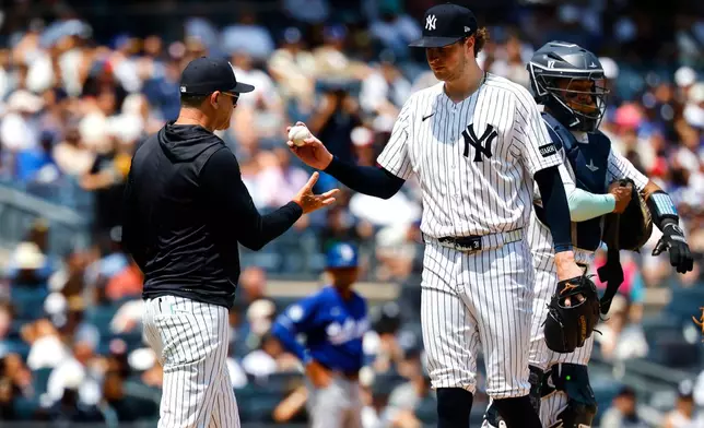 New York Yankees manager Aaron Boone, left, takes the ball from pitcher Cam Schlittler, second from left, during the fifth inning of the first game of a baseball doubleheader against the Los Angeles Dodgers, Sunday, July 19, 2026, in New York. (AP Photo/Noah K. Murray)