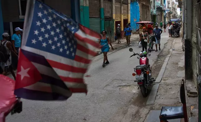 People walk on the street during a blackout in Havana, Cuba, Monday, July 6, 2026. (AP Photo/Ramon Espinosa)