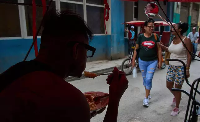 A pedicab driver eats from his bike during a blackout in Havana, Cuba, Monday, July 6, 2026. (AP Photo/Ramon Espinosa)