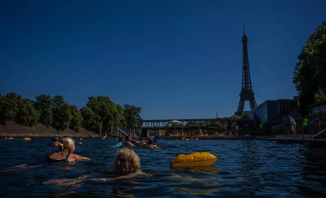 People swim in the Seine River, Saturday, July 4, 2026 in Paris. (AP Photo/Aurelien Morissard)