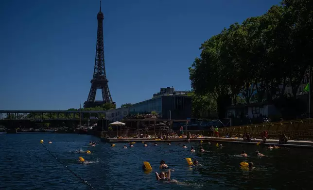 People swim in the Seine River, Saturday, July 4, 2026 in Paris. (AP Photo/Aurelien Morissard)