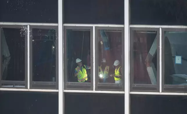 People inspect a buckled support beam inside 235 East 42nd Street, Wednesday, July 8, 2026, in New York. (AP Photo/Yuki Iwamura)
