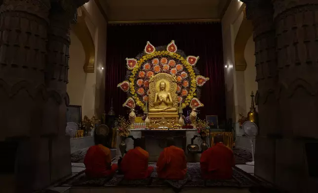 Buddhist monks pray inside a monastery in Sarnath, India, Saturday, July 18, 2026. (AP Photo/Rajesh Kumar Singh)