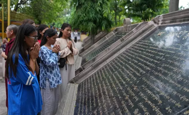 Visitors offer prayers outside a monastery in Sarnath, India, Saturday, July 18, 2026. (AP Photo/Rajesh Kumar Singh)