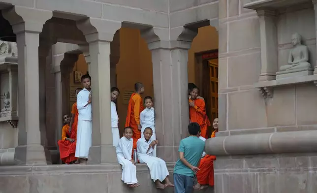 Novice Buddhists wait to enter a monastery for prayers at the ancient Buddhist site of Sarnath, India, Saturday, July 18, 2026. (AP Photo/Rajesh Kumar Singh)