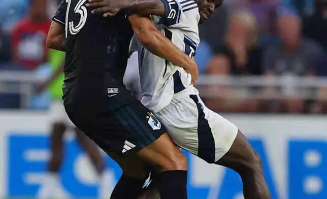 Minnesota United FC defense Anthony Markanich (13) and Vancouver Whitecaps FC offense Cheikh Sabaly (7) battle for the ball during the first half of an MLS soccer match on Saturday, July 25, 2026, in St. Paul, Minn. (AP Photo/Adam Bettcher)