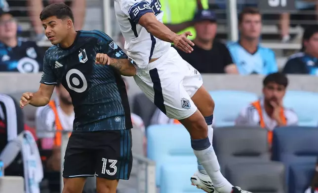 Vancouver Whitecaps FC defense Mathias Laborda (2) heads the ball over Minnesota United FC defense Anthony Markanich (13) during the first half of an MLS soccer match on Saturday, July 25, 2026, in St. Paul, Minn. (AP Photo/Adam Bettcher)