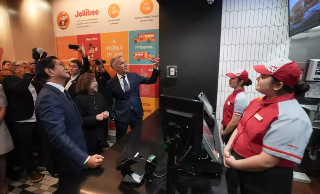 Canada's Prime Minister Mark Carney, back, Philippines President Ferdinand Marcos Jr., left, and Jollibee Group North America president Beth Dela Cruz place an order during a visit to a Jollibee fast food restaurant, in Vancouver, Thursday, July 2, 2026. (Darryl Dyck/The Canadian Press via AP)