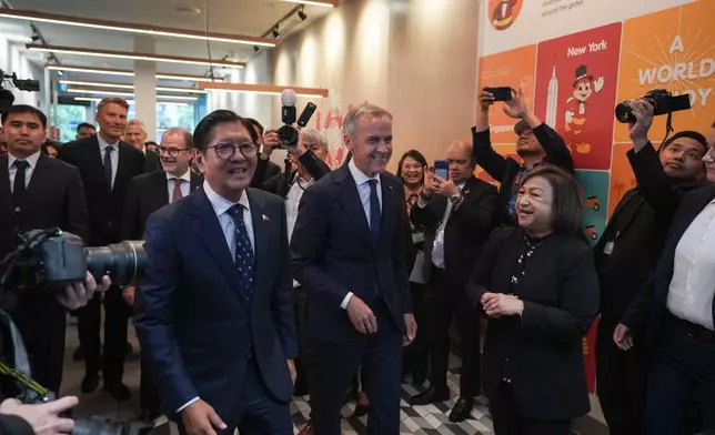 Canada's Prime Minister Mark Carney, center, and Philippines President Ferdinand Marcos Jr., right, arrive for a visit to a Jollibee fast food restaurant, in Vancouver, Thursday, July 2, 2026. (Darryl Dyck/The Canadian Press via AP)