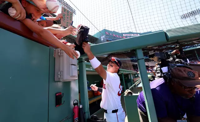 Boston Red Sox shortstop Tsung-Che Cheng signs autographs for fans before the first baseball game of a doubleheader against the Tampa Bay Rays, Friday, July 17, 2026, in Boston. (AP Photo/Mark Stockwell)