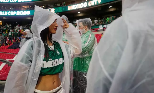 A fan wears a poncho as it rains ahead of the World Cup round of 32 soccer match between Mexico and Ecuador in Mexico City, Tuesday, June 30, 2026. (AP Photo/Ricardo Mazalan)