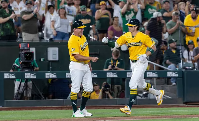 Athletics' Tyler Soderstrom, right, fist bumps third base coach Bobby Crosby after hitting a two-run home run during the sixth inning of a baseball game against the Washington Nationals, Saturday, July 18, 2026, in West Sacramento, Calif. (AP Photo/Sara Nevis)