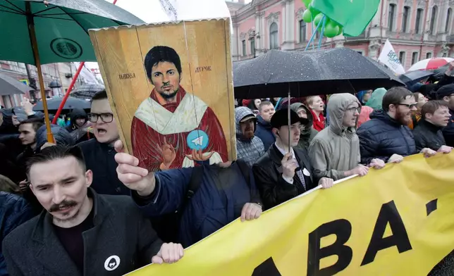 FILE - Protesters hold a portrait of messaging app Telegram co-founder Pavel Durov designed as an icon, protesting against the blocking of the app in Russia, during a May Day rally in St. Petersburg, Russia, Tuesday, May 1, 2018. (AP Photo, File)