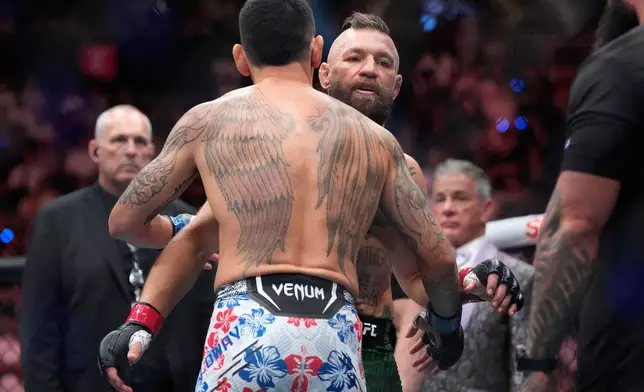 Conor McGregor, right, embraces Max Holloway after McGregor lost in a welterweight fight at the UFC 329 mixed martial arts event Saturday, July 11, 2026, in Las Vegas. (AP Photo/John Locher)