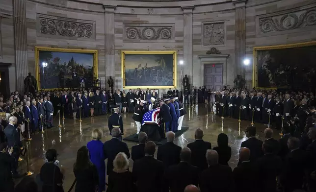An Armed Forces Body Bearer Team places the flag-draped casket of Sen. Lindsey Graham of South Carolina, in the Rotunda of the U.S. Capitol, Tuesday, July 28, 2026, in Washington. (AP Photo/Allison Robbert)