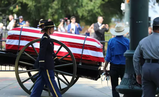 The flag-draped casket of U.S. Sen. Lindsey Graham, R-S.C., is carried on a horse-drawn caisson to his funeral at First Baptist Church in Columbia, S.C., on Wednesday, July 29, 2026. (AP Photo/Jeffrey Collins).