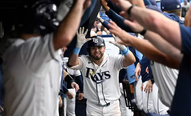 Tampa Bay Rays' Jonathan Aranda, center, is congratulated by teammates in the dugout after hitting a two-run home run during the eighth inning of a baseball game against the Seattle Mariners, Sunday, July 12, 2026, in St. Petersburg, Fla. (AP Photo/Phelan M. Ebenhack)