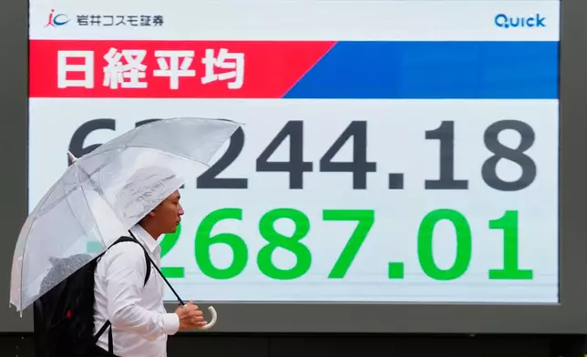 A person walks in front of an electronic stock board showing Japan's Nikkei index at a securities firm Tuesday, July 28, 2026, in Tokyo. (AP Photo/Eugene Hoshiko)