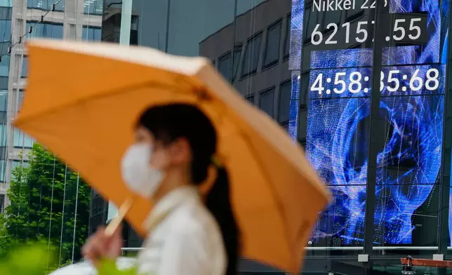 A person walks in front of an electronic stock board showing Japan's Nikkei index at a securities firm Tuesday, July 28, 2026, in Tokyo. (AP Photo/Eugene Hoshiko)