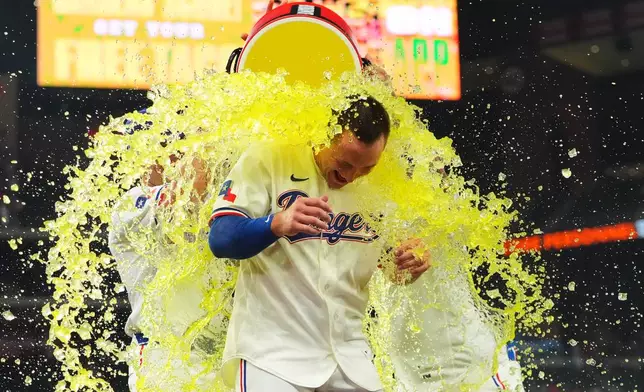Texas Rangers' Wyatt Langford is doused after hitting the winning single in the ninth inning of a baseball game against the Los Angeles Angels, Thursday, July 9, 2026, in Arlington, Texas. (AP Photo/LM Otero)