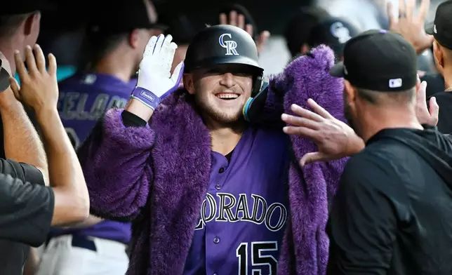Colorado Rockies' Hunter Goodman celebrates in the dugout after hitting a two-run home run in the fifth inning of a baseball game against the Miami Marlins Wednesday, July 1, 2026, in Denver. (AP Photo/Geneva Heffernan)