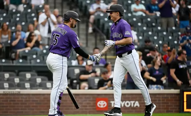 Colorado Rockies' Hunter Goodman (15) and Mickey Moniak celebrate after Moniak hit a home run in the first inning of a baseball game against the Miami Marlins Wednesday, July 1, 2026, in Denver. (AP Photo/Geneva Heffernan)