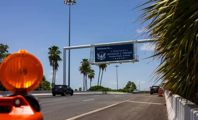 Airport visitors drive under a sign displaying the name of the rebranded Donald J. Trump International Airport in West Palm Beach, Fla., Thursday, July 9, 2026. (AP Photo/Saul Martinez)