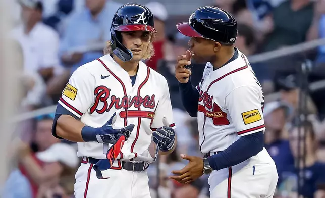 Atlanta Braves' Jim Jarvis, left, reacts with first base coach Antoan Richardson, right, after hitting an RBI single against the New York Mets during the second inning of a baseball game, Monday, July 6, 2026, in Atlanta. (AP Photo/Erik S. Lesser)