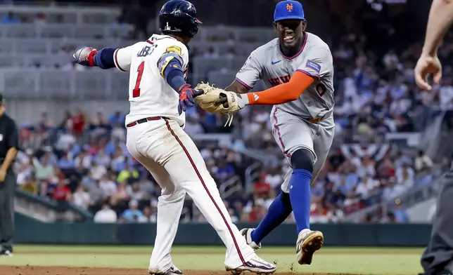 New York Mets shortstop Ronny Mauricio, right, tags out Atlanta Braves' Ozzie Albies, left, between second base and third during the fifth inning of a baseball game, Monday, July 6, 2026, in Atlanta. (AP Photo/Erik S. Lesser)