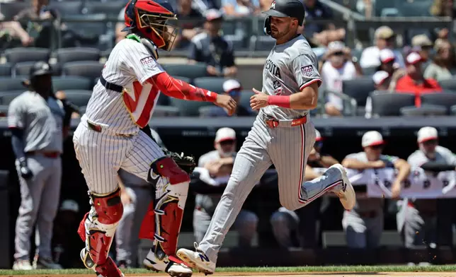 Minnesota Twins' Trevor Larnach (9) scores a run past New York Yankees catcher Ali Sánchez during the first inning of a baseball game Saturday, July 4, 2026, in New York. (AP Photo/Adam Hunger)