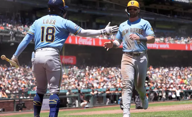 Milwaukee Brewers' Jake Bauers, right, is congratulated by Luis Lara (18) after scoring against the San Francisco Giants during the fourth inning of a baseball game, Wednesday, July 29, 2026, in San Francisco. (AP Photo/Jeff Chiu)