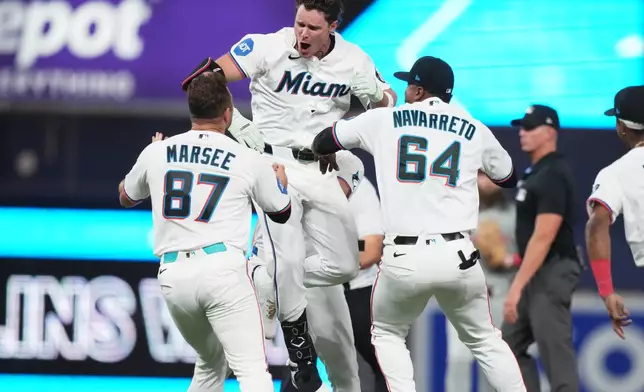 Miami Marlins' Griffin Conine, center, celebrates after hitting a walk off single to score Heriberto Hernández and defeat the Philadelphia Phillies in the the ninth inning of a baseball game, Monday, July 27, 2026, in Miami. (AP Photo/Lynne Sladky)