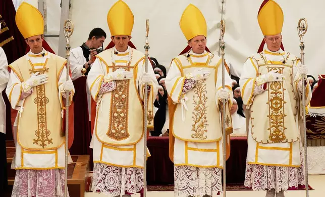 Newly consecrated Bishops, from left, Marc Hanappier, Michel Poinsinet de Sivry, Michael Goldade and Pascal Schreiber wearing their miters and holding their pastoral staffs, stand at the end of their consecration ceremony in a tent set up outside the Society of St. Pius X seminary in Econe, Switzerland, Wednesday, July 1, 2026. (AP Photo/Baz Ratner)