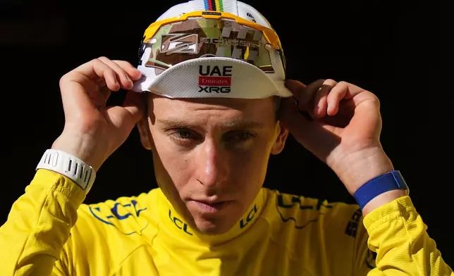Slovenia's Tadej Pogacar, wearing the overall leader's yellow jersey arrives on the podium after the seventeenth stage of the Tour de France cycling race, with start in Chambery and finish in Voiron France, Wednesday, July 22, 2026. (AP Photo/Thibault Camus)