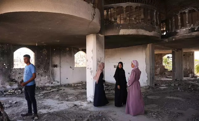 Fady al-Gharam, left, and his sisters inspect their family's home which was damaged during the Israel-Hamas war, in Nuseirat, central Gaza Strip, Thursday, June 4, 2026, while they are in the process of obtaining Israeli passports. (AP Photo)