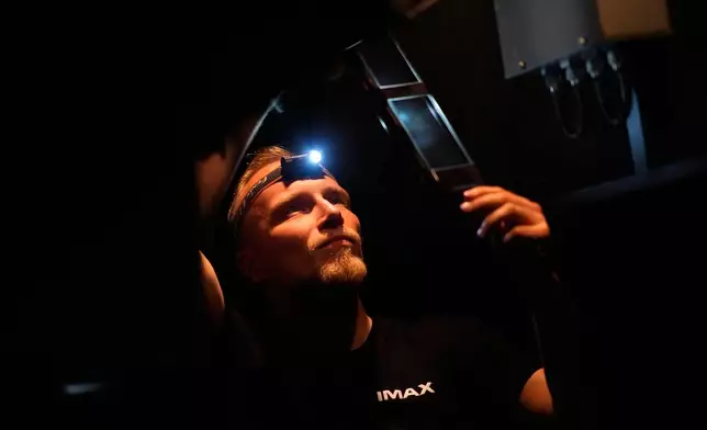 Tomas Vysinsky prepares the 70 mm IMAX copy of Christopher Nolan's "The Odyssey" for screening in Prague, Czech Republic, Monday, July 27, 2026. (AP Photo/Petr David Josek)