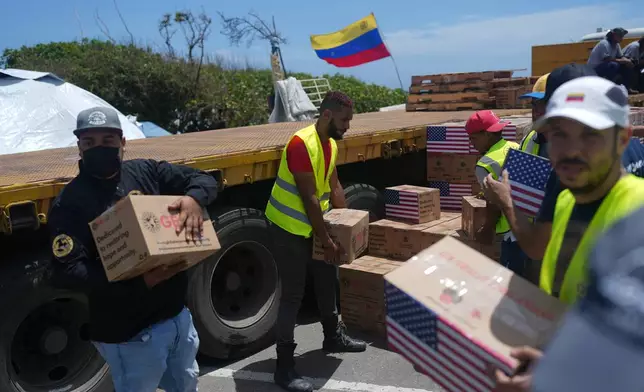 Relief workers unload U.S. humanitarian aid for people affected by the earthquakes in La Guaira, Venezuela, Wednesday, July 8, 2026. (AP Photo/Ariana Cubillos)
