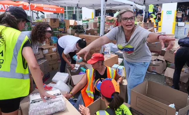 Lisa Galindez calls on other volunteers to help pack baby items at the Global Empowerment Mission Venezuela relief donation site Tuesday, June 30, 2026, in Doral, Fla. (AP Photo/Marta Lavandier)