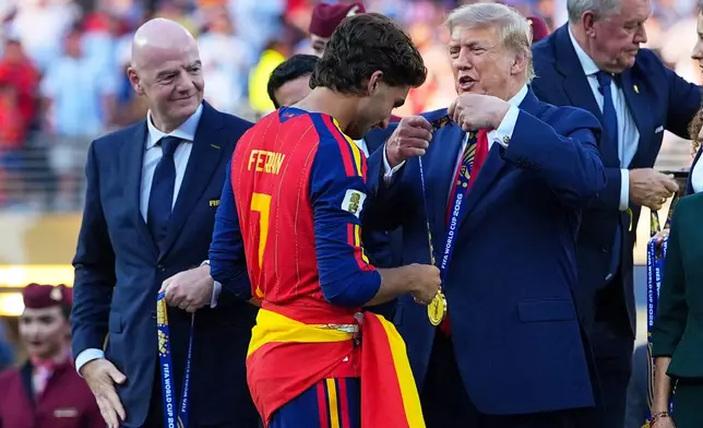 President Donald J. Trump gives Spain's Ferran Torres (7) winners metal during the World Cup final soccer match between Spain and Argentina in East Rutherford, N.J., near New York, Sunday, July 19, 2026. (AP Photo/Julio Cortez)