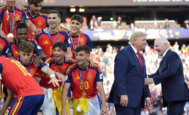 Spain players, from left, cheer alongside President Donald Trump and FIFA President Gianni Infantino at the conclusion of the World Cup championship final soccer match between Spain and Argentina in East Rutherford, N.J., Sunday, July 19, 2026. (AP Photo/Jacquelyn Martin)