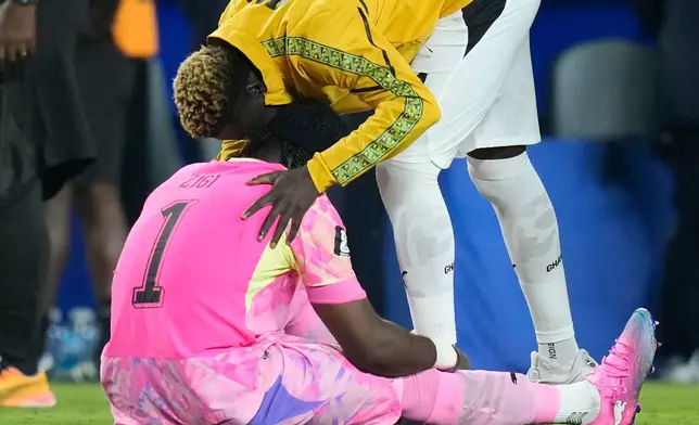 Ghana goalkeeper Lawrence Ati-Zigi (1) is comforted by teammate Kojo Peprah Oppong (21) after the World Cup round of 32 soccer match between Colombia and Ghana in Kansas City, Mo., Friday, July 3, 2026. (AP Photo/John Locher)