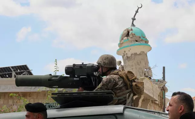 A Lebanese soldier looks through the binoculars of an anti-tank launcher in front of a destroyed mosque after deploying in the village of Zawtar al-Gharbiyeh, southern Lebanon, Sunday, July 26, 2026. (AP Photo/Ahmad Mantash)