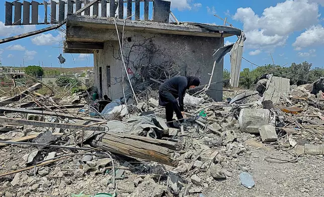 A Lebanese woman clears debris of her destroyed house in the village of Zawtar al-Gharbiyeh, southern Lebanon, Sunday, July 26, 2026. (AP Photo/Ahmad Mantash)
