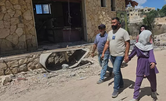 People walk through the village of Zawtar al-Gharbiyeh after the Lebanese army deployed to the village in southern Lebanon, Sunday, July 26, 2026. (AP Photo/Ahmad Mantash)