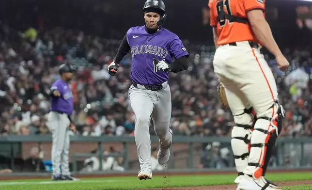 Colorado Rockies' Ezequiel Tovar, middle, runs home to score against the San Francisco Giants during the fifth inning of a baseball game, Friday, July 10, 2026, in San Francisco. (AP Photo/Jeff Chiu)
