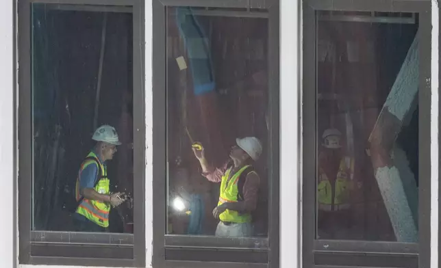 People inspect a buckled support beam inside 235 East 42nd Street, Wednesday, July 8, 2026, in New York. (AP Photo/Yuki Iwamura)